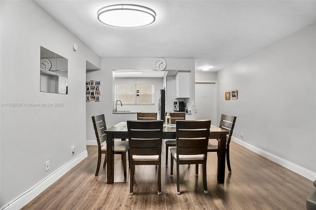 dining room with hardwood / wood-style floors and sink