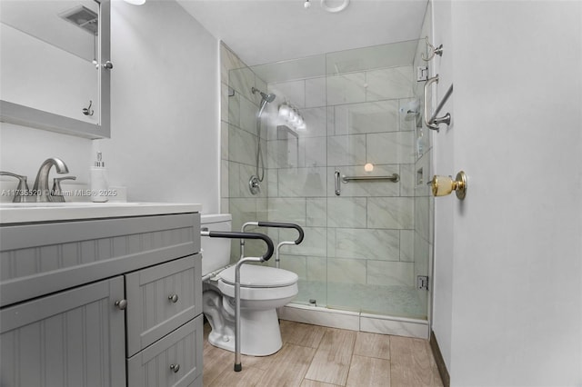 bathroom featuring vanity, an enclosed shower, and toilet