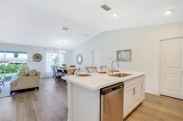 kitchen featuring stainless steel dishwasher, sink, a kitchen island with sink, and white cabinets