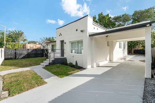 view of front of property with a carport and a front yard