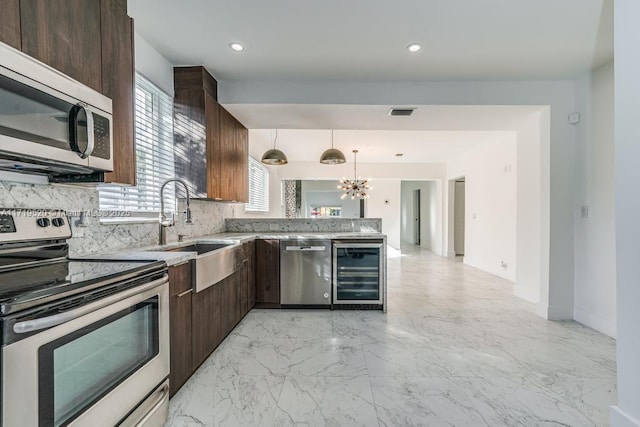 kitchen featuring dark brown cabinetry, wine cooler, appliances with stainless steel finishes, and backsplash