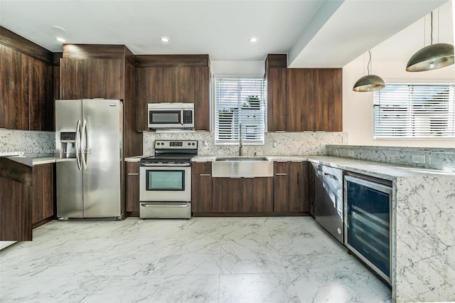 kitchen featuring dark brown cabinetry, beverage cooler, a sink, marble finish floor, and appliances with stainless steel finishes