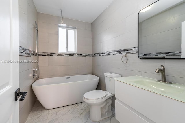 full bathroom with marble finish floor, tile walls, a soaking tub, toilet, and vanity