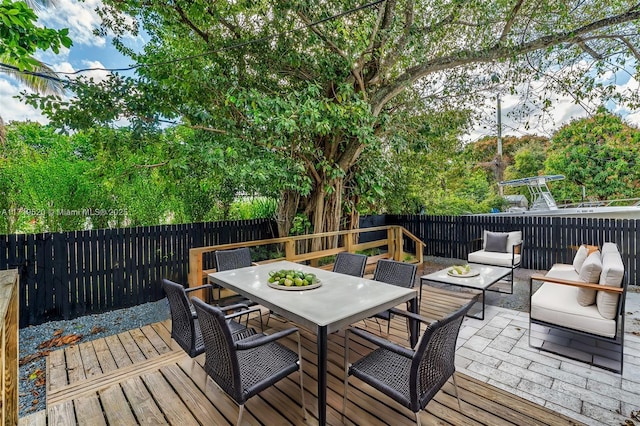 deck featuring a fenced backyard and outdoor dining area