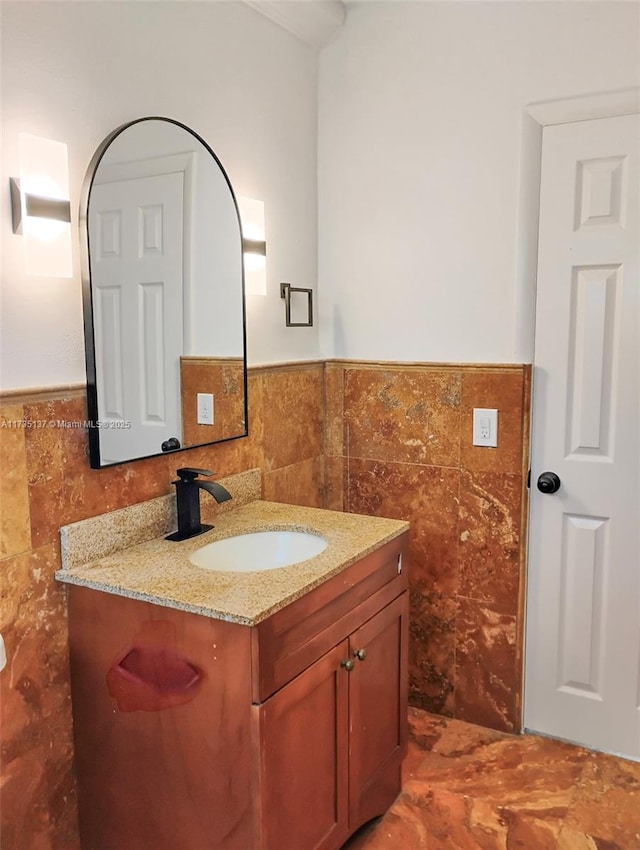 bathroom with vanity and tile walls