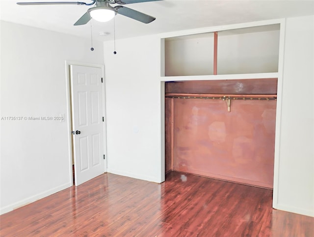 unfurnished bedroom with dark wood-type flooring, a closet, and ceiling fan