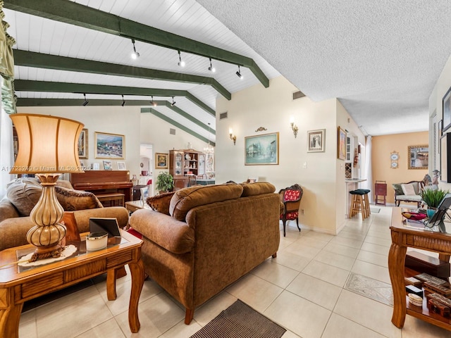 tiled living room with lofted ceiling with beams, track lighting, and a textured ceiling