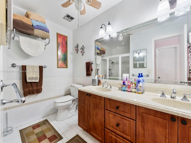 bathroom with ceiling fan, tile walls, tile patterned flooring, an enclosed shower, and vanity