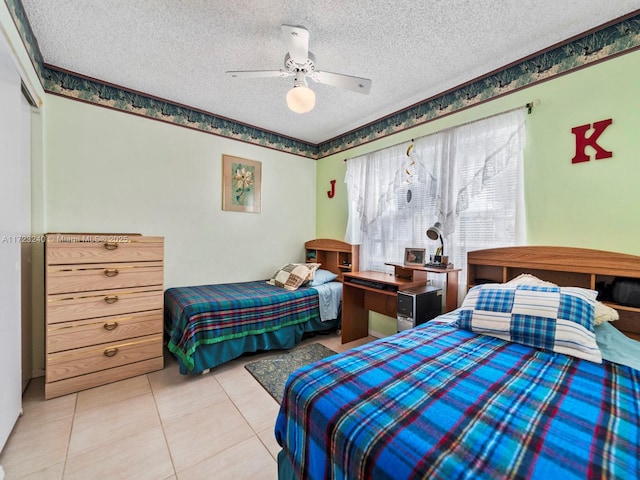 bedroom with light tile patterned floors, a closet, a textured ceiling, and ceiling fan