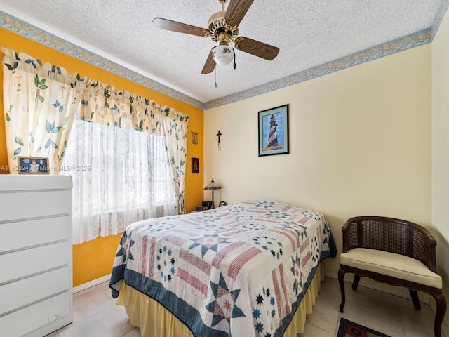 bedroom with ceiling fan, a textured ceiling, and light tile patterned floors