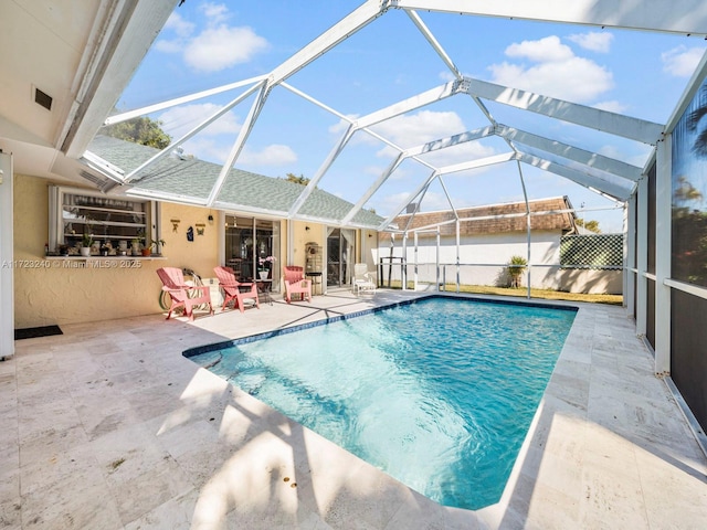 view of swimming pool featuring a patio and glass enclosure