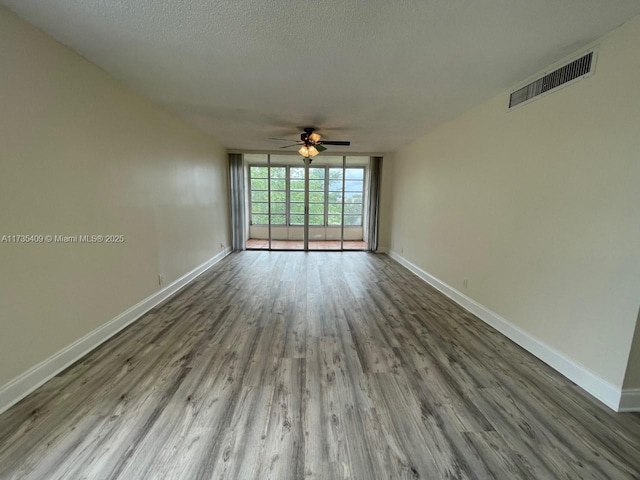 spare room featuring hardwood / wood-style flooring, ceiling fan, and a textured ceiling