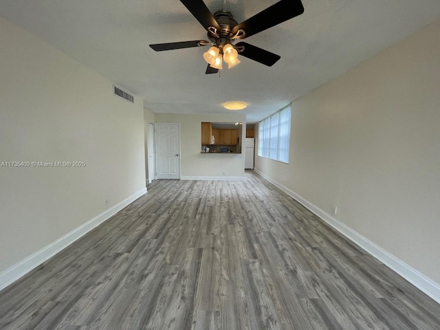 unfurnished living room featuring hardwood / wood-style flooring and ceiling fan