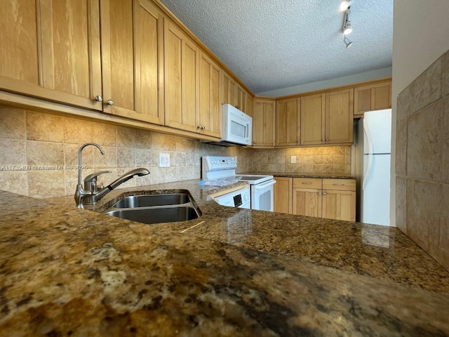 kitchen featuring sink, white appliances, dark stone countertops, tasteful backsplash, and a textured ceiling