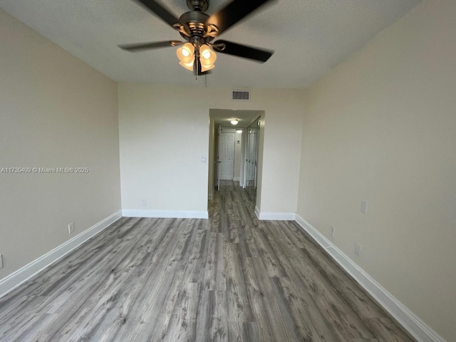 spare room with ceiling fan, light hardwood / wood-style flooring, and a textured ceiling