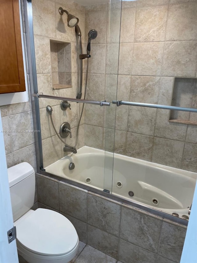 bathroom featuring shower / bath combination with glass door and toilet