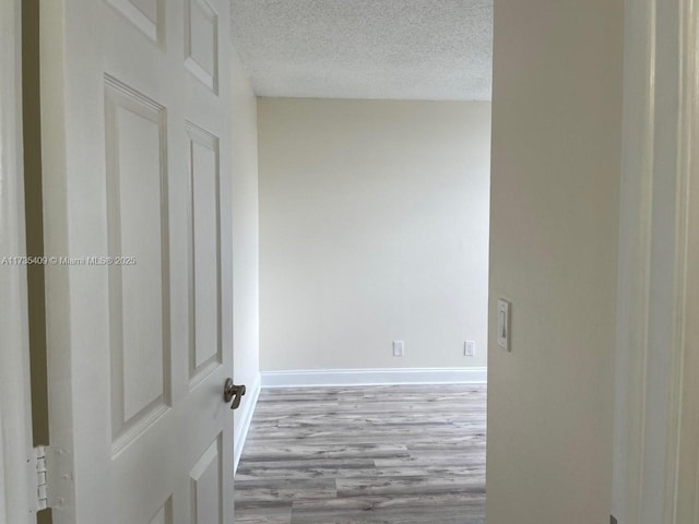 spare room featuring a textured ceiling and light wood-type flooring