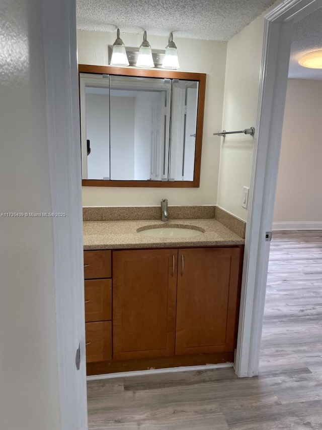 bathroom featuring vanity, hardwood / wood-style floors, and a textured ceiling