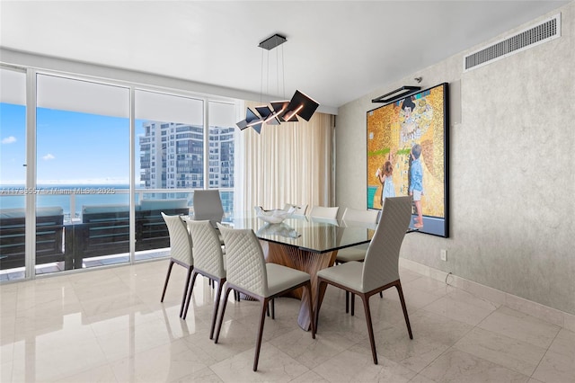 dining room featuring a water view, plenty of natural light, and floor to ceiling windows