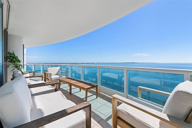 balcony featuring outdoor lounge area and a water view