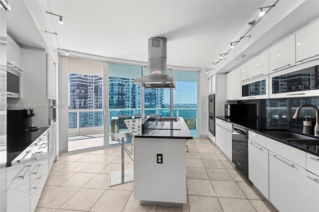 kitchen with a breakfast bar area, white cabinetry, a center island, island exhaust hood, and black appliances