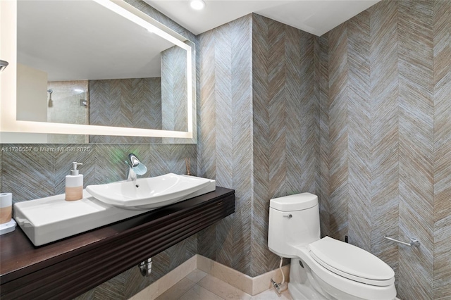 bathroom featuring sink, tile walls, and toilet