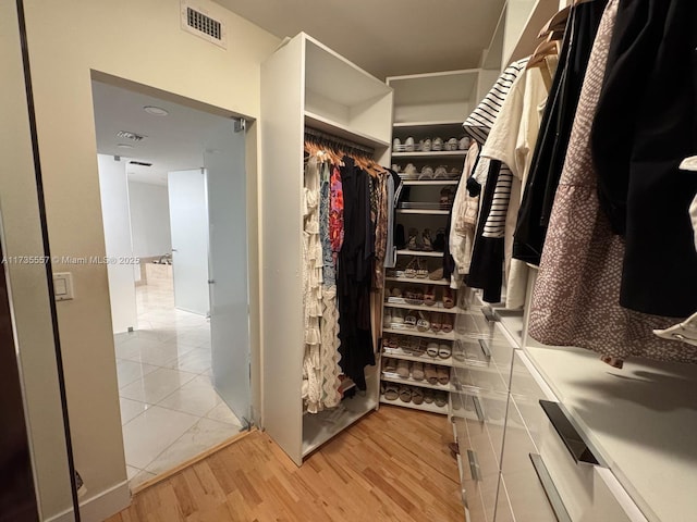 walk in closet with light wood-type flooring