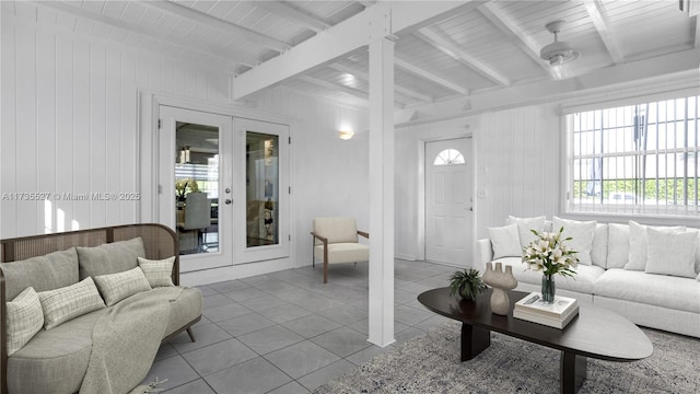 tiled living room featuring wood ceiling, beamed ceiling, french doors, and a healthy amount of sunlight