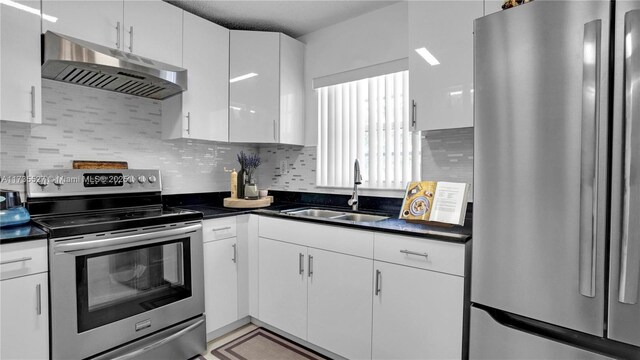 kitchen with white cabinetry, sink, decorative backsplash, and appliances with stainless steel finishes