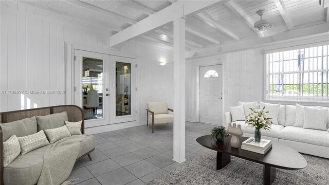 living room featuring beamed ceiling, a wealth of natural light, light tile patterned floors, and french doors