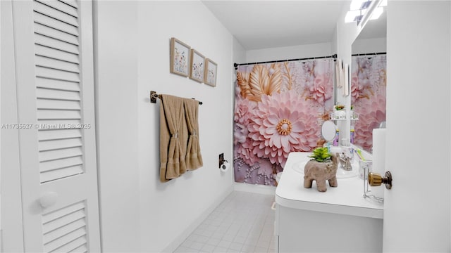 bathroom with curtained shower and tile patterned flooring