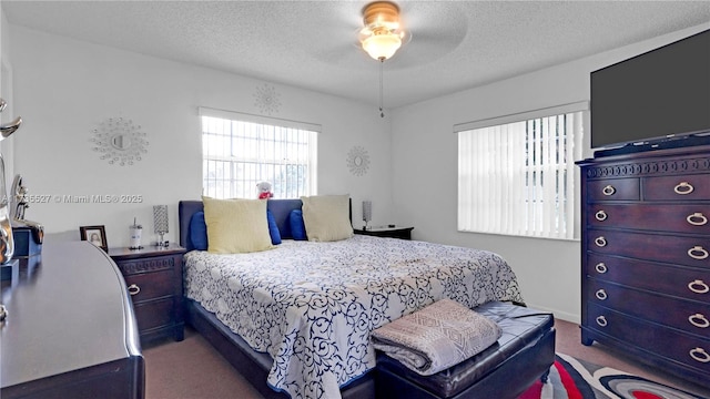 carpeted bedroom with ceiling fan and a textured ceiling