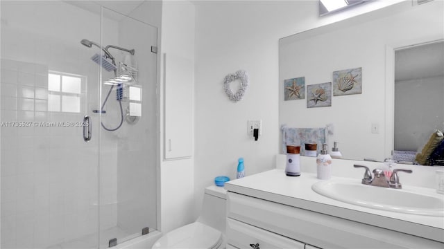 bathroom with vanity, a shower with shower door, and toilet