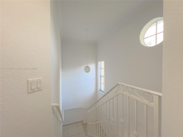 stairway featuring ornamental molding and tile patterned flooring