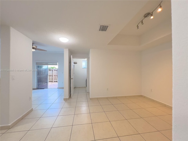 tiled empty room with rail lighting and ceiling fan