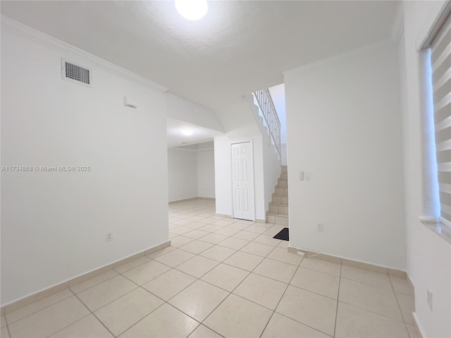 spare room featuring light tile patterned floors and ornamental molding