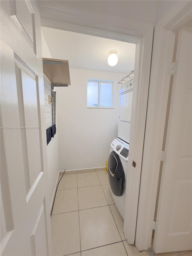 clothes washing area featuring light tile patterned flooring and stacked washer / dryer