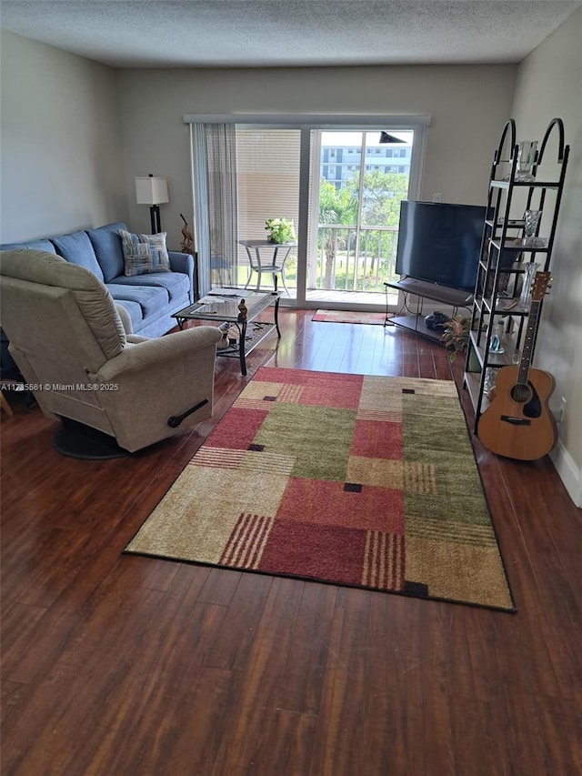 living room featuring a textured ceiling and dark hardwood / wood-style flooring