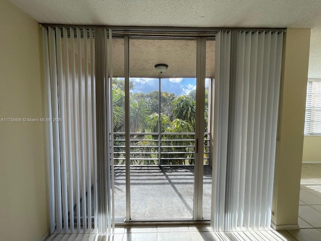 doorway to outside with a textured ceiling