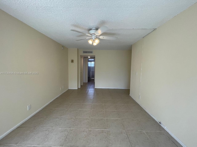 tiled empty room with ceiling fan and a textured ceiling