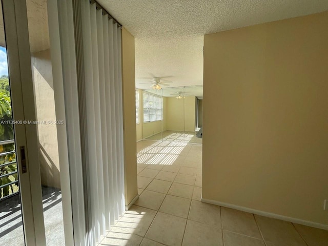 hallway featuring light tile patterned floors and a textured ceiling