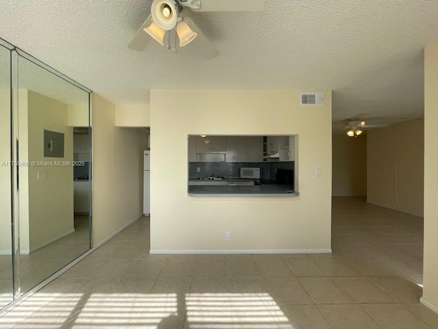 unfurnished living room featuring light tile patterned flooring, a textured ceiling, electric panel, and ceiling fan