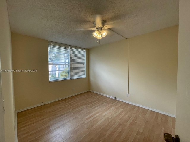 spare room featuring ceiling fan, a textured ceiling, and light wood-type flooring
