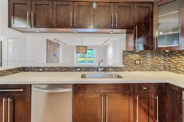 kitchen featuring stainless steel dishwasher, decorative light fixtures, sink, and backsplash