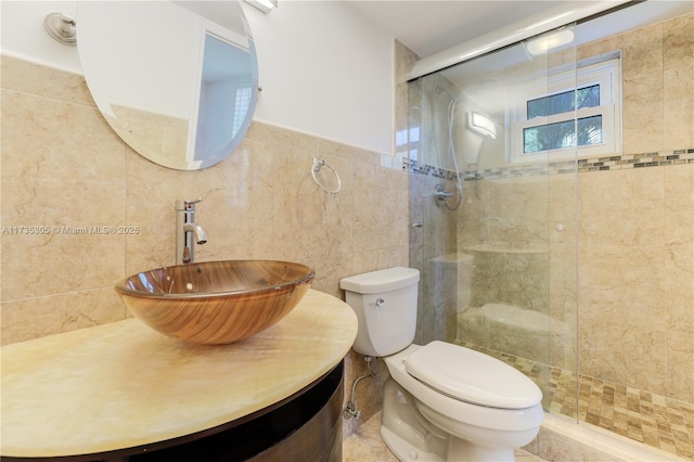 bathroom featuring an enclosed shower, vanity, tile walls, and toilet