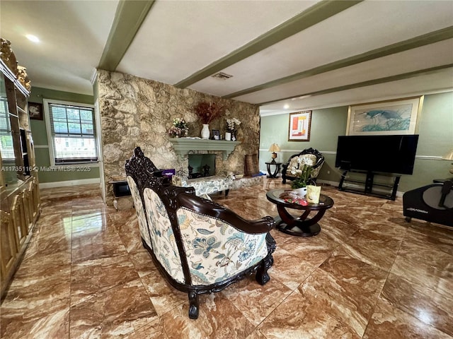 living room featuring beam ceiling, ornamental molding, and a fireplace