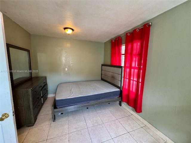 bedroom with light tile patterned flooring and a textured ceiling