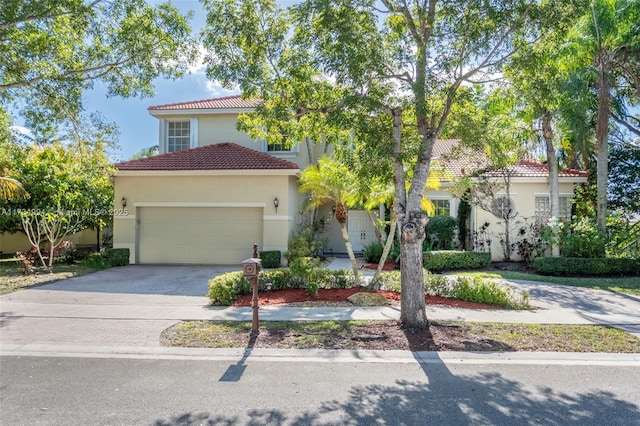 mediterranean / spanish-style home with a tile roof, decorative driveway, a garage, and stucco siding