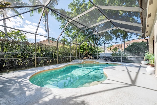 outdoor pool with glass enclosure and a patio