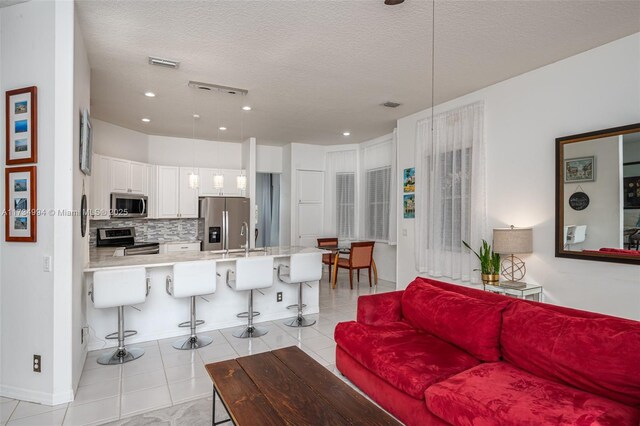 living area featuring tile patterned floors, baseboards, and a ceiling fan